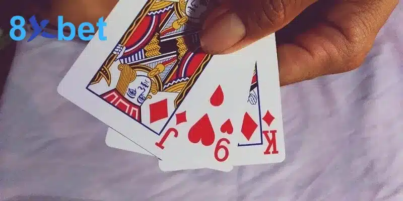 Bộ bài cào 3 lá gồm J rô, 9 cơ và K rô được xòe trên tay, tổng điểm đạt 9 nút