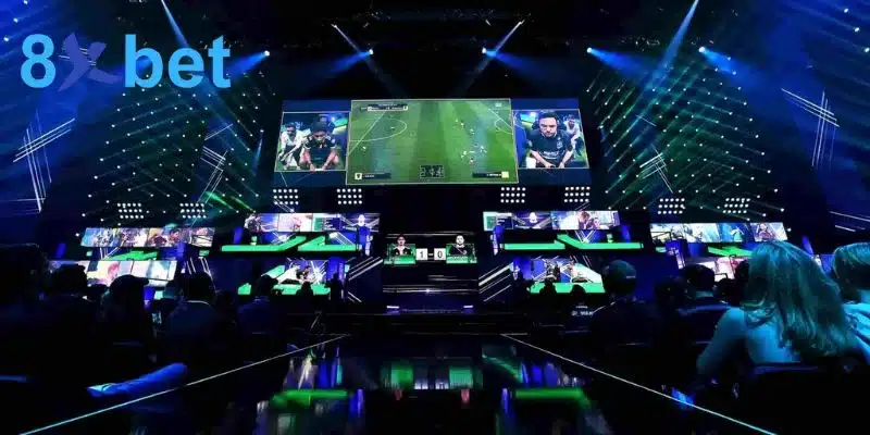 Sân khấu cá cược esports với trận bóng đá điện tử chiếu trên màn hình trung tâm và đèn xanh