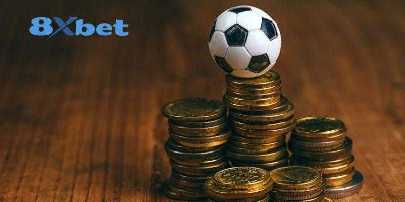 Quả bóng đặt trên chồng đồng xu vàng, minh họa việc dùng bảng xếp hạng world cup khi xem kèo
