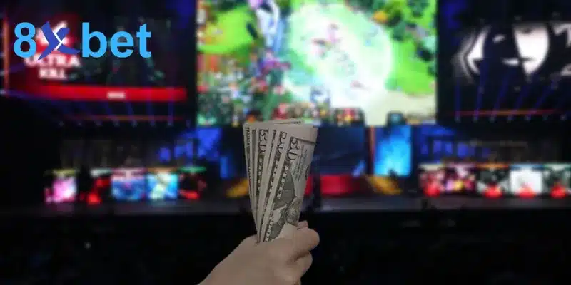 Người chơi cá cược esports cầm xấp tiền trước màn hình lớn đang chiếu trận game MOBA