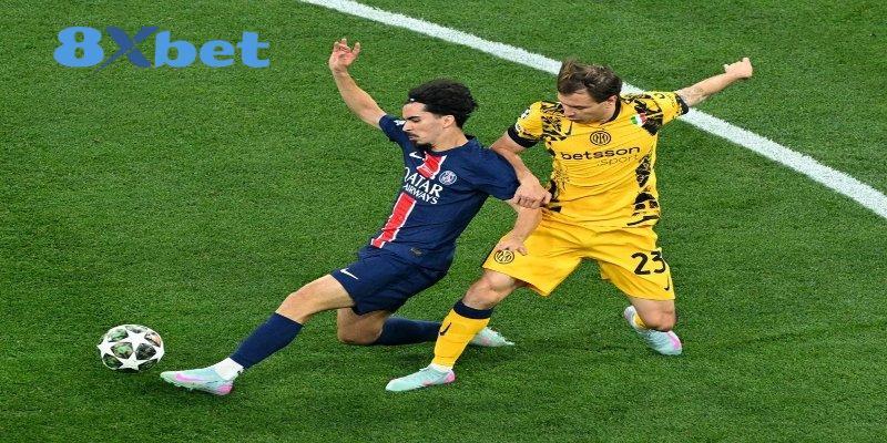 Cầu thủ áo xanh đậm và cầu thủ áo vàng số 23 tranh bóng trên mặt cỏ, minh họa bài tổng hợp kênh phát sóng world cup