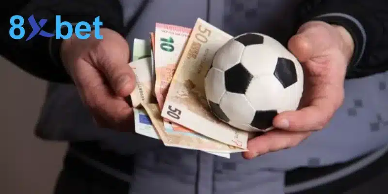 Hai bàn tay cầm xấp tiền euro và quả bóng, minh họa mẹo đặt cược bóng đá bắt đầu từ việc hiểu kèo