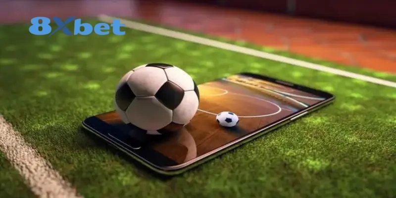 Quả bóng đá đặt trên điện thoại hiển thị sân đấu, gợi nhắc việc xem tỷ lệ kèo world cup trên di động