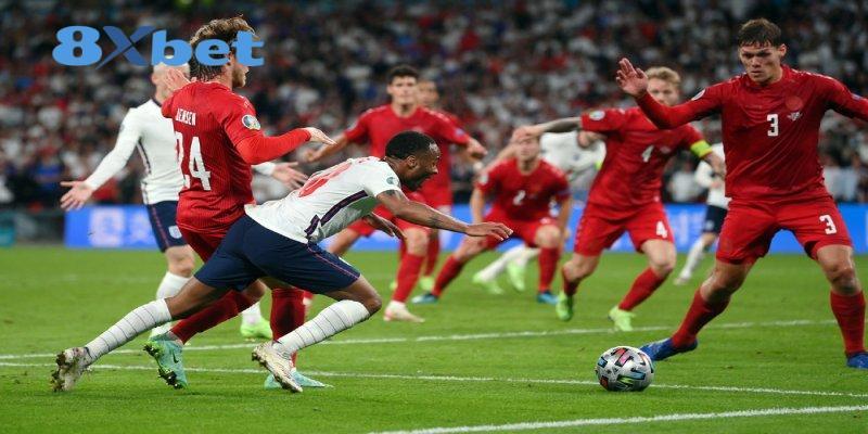 Cầu thủ áo trắng ngã về phía trước giữa vòng vây hậu vệ áo đỏ, khung cảnh quen thuộc khi xem trực tiếp World Cup